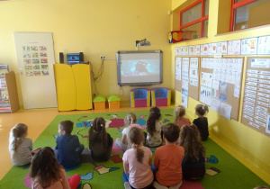 Dzieci oglądają z zainteresowaniem animację oraz film edukacyjny na temat „Co to jest i jak powstaje wulkan”